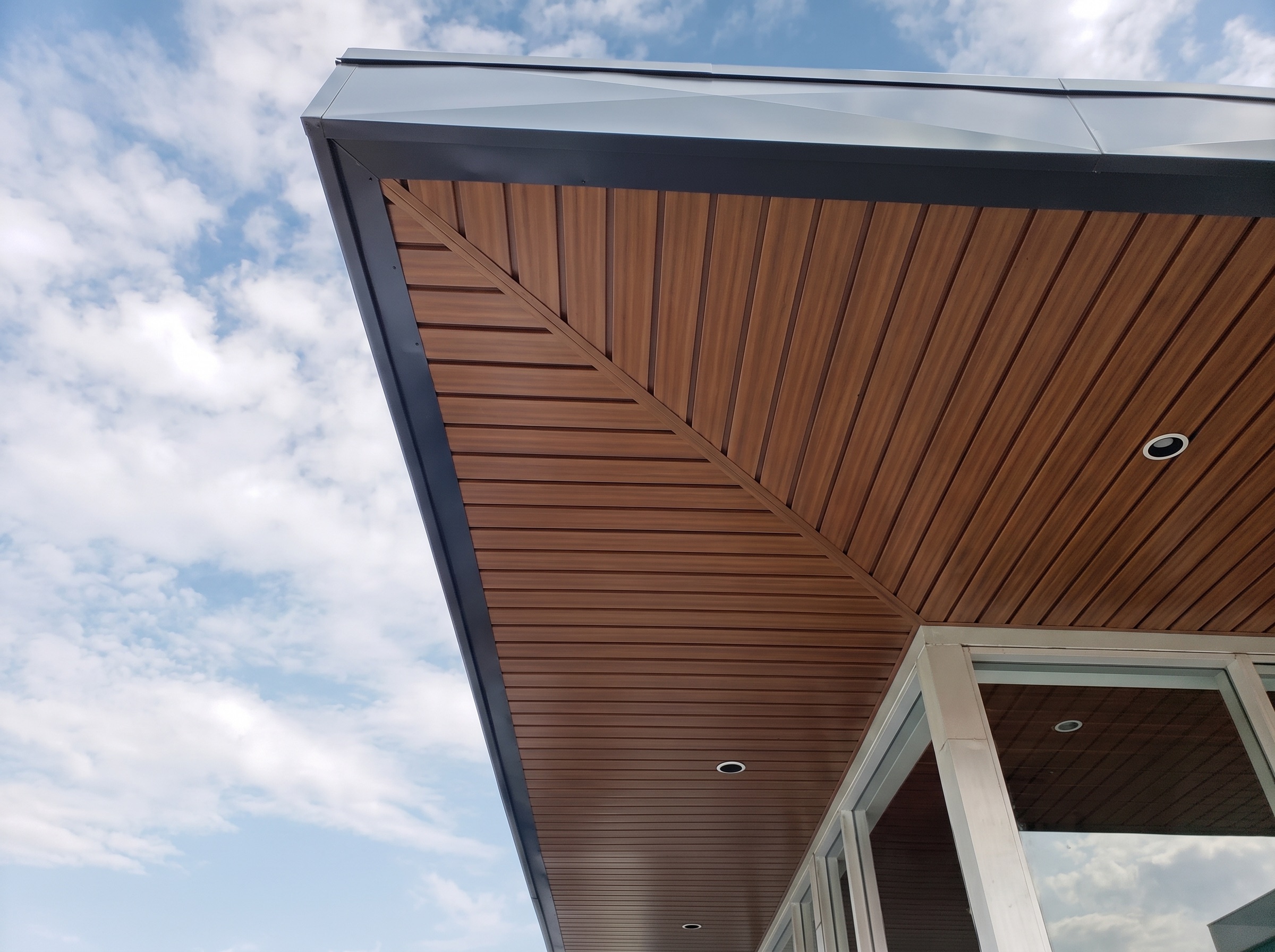 Weather-resistant wood-look soffit ceiling under a covered walkway, installed by Maynard